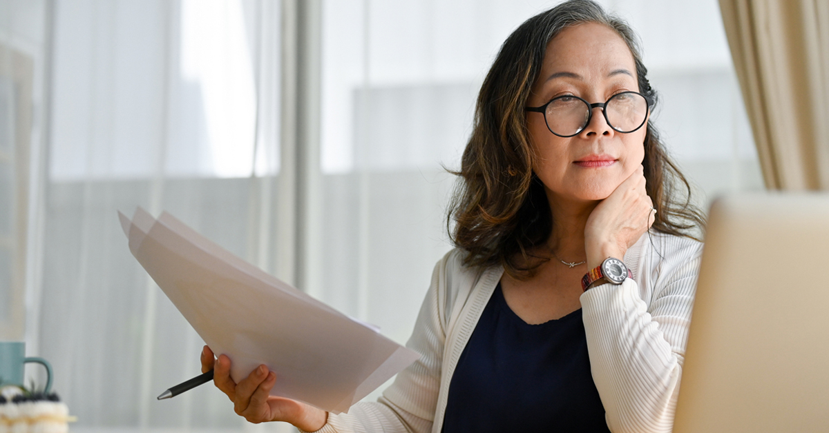Une jeune femme d'affaires sourit avec assurance dans un cadre professionnel, incarnant la réussite et le professionnalisme.